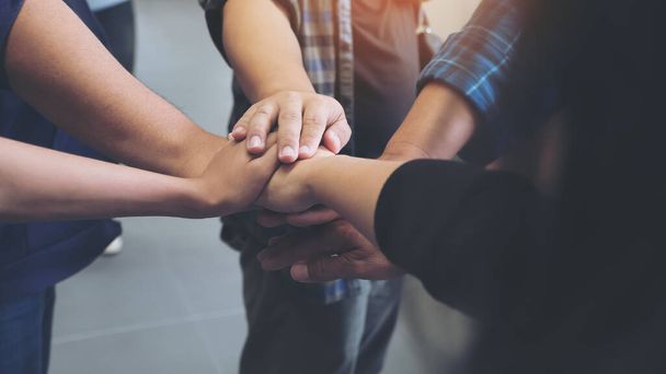 Closeup image of business team standing and joining their hands together in office  - Photo, Image