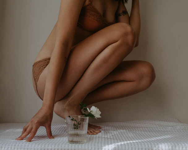 woman in lingerie with glass and dog rose - Photo, Image