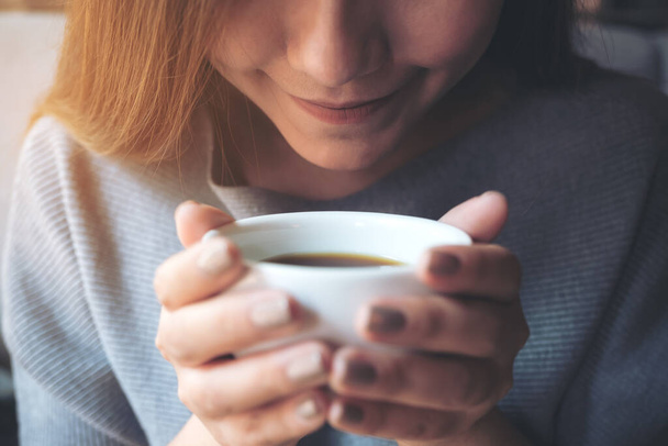 Imagem de close-up da mulher asiática cheirando e bebendo café quente com sentir-se bem no café - Foto, Imagem