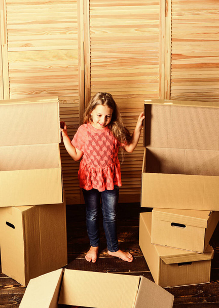 At your service. happy child cardboard box. repair of room. new apartment. happy little girl with bear toy. Cardboard boxes - moving to new house. purchase of new habitation - Фото, изображение