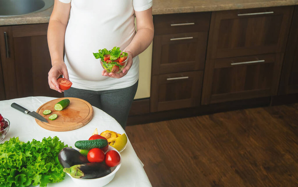 Těhotná žena jí zeleninu a ovoce. Selektivní soustředění. Jídlo. - Fotografie, Obrázek