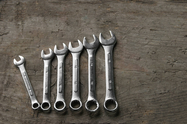 Wrenches of different sizes isolated on wood background. Top view - Photo, Image