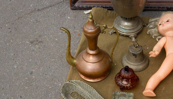 Ein Flohmarkt mit einem großen Sortiment an Antiquitäten, Kupferkrügen und Schmuckstücken zum Verkauf - Foto, Bild
