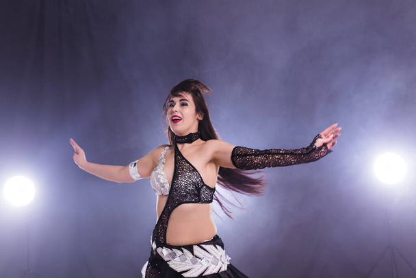 ベリーダンサー。若い魅力的な女性がステージ上で部族の融合を踊ります。東洋のエキゾチックなダンス. - 写真・画像