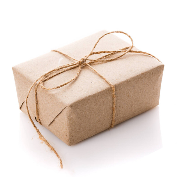 Κουτί δώρου τυλιγμένο με λευκό χαρτί και κορδέλα λινάτσα που απομονώνεται σε λευκό φόντο. - Φωτογραφία, εικόνα