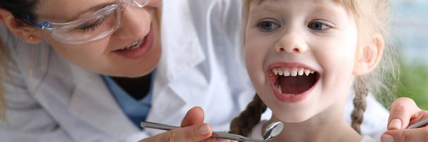 Dentystka bada zęby w klinice u dziecka - Zdjęcie, obraz