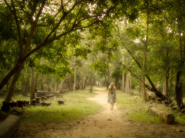 jonge vrouw lopen op mysterieuze pad naar enchanted forest - Foto, afbeelding