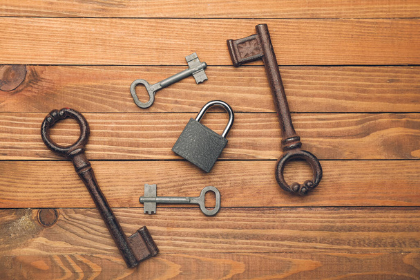Schlüssel mit Schloss auf Holzgrund - Foto, Bild