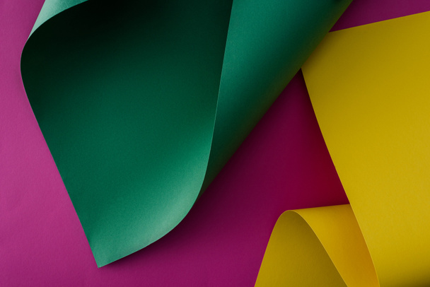 verde y amarillo colorido papel remolinos sobre fondo púrpura
 - Foto, Imagen