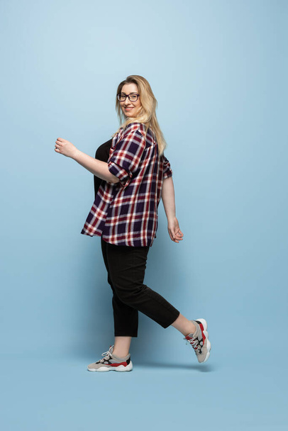 Young caucasian woman in casual wear on blue background. Bodypositive female character, plus size businesswoman - Фото, зображення
