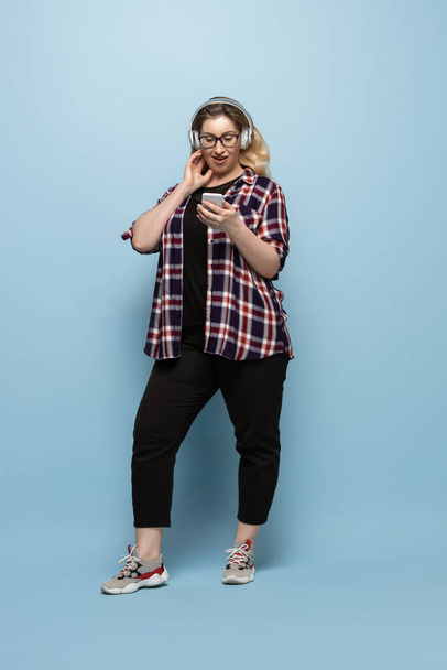 Young caucasian woman in casual wear on blue background. Bodypositive female character, plus size businesswoman - Fotoğraf, Görsel