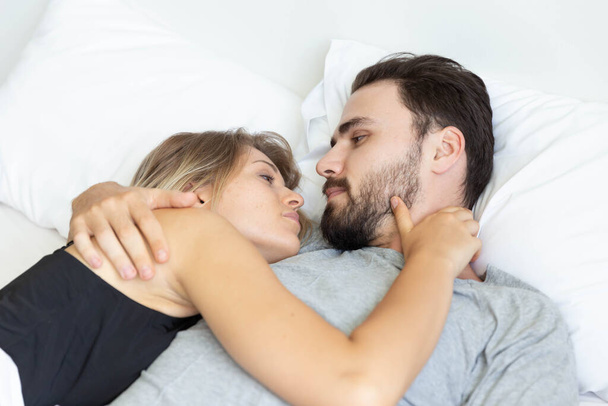 Young cute couple hug and sleep together in bed - Fotoğraf, Görsel