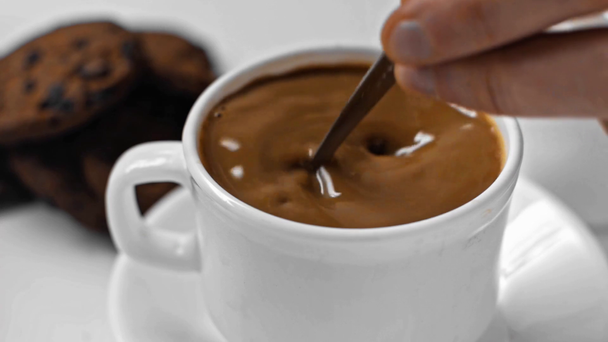 Медленное движение человека, перемешивающего кофе ложкой на белом
 - Кадры, видео