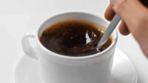 Mouvement lent de l'homme en remuant café instantané dans une tasse sur blanc - Séquence, vidéo