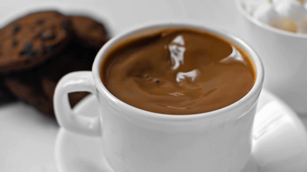 foyer sélectif de l'homme en remuant le café dans une tasse sur blanc - Séquence, vidéo