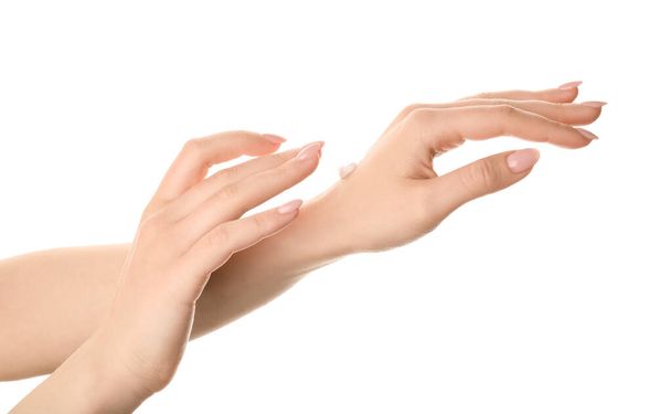 Όμορφη νεαρή γυναίκα εφαρμογή κρέμα χεριών σε λευκό φόντο - Φωτογραφία, εικόνα