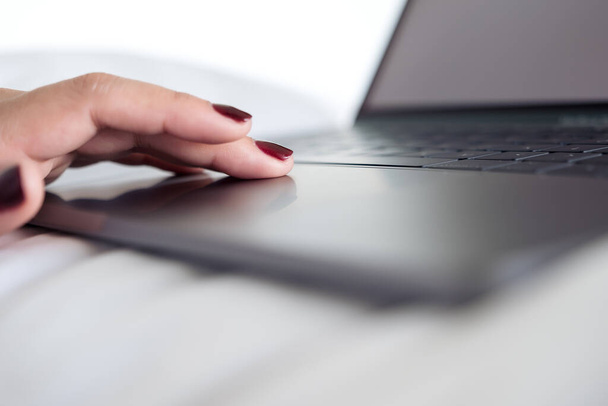 Immagine ravvicinata delle mani della donna utilizzando e toccando la tastiera del computer portatile con sfondo di scrittura  - Foto, immagini