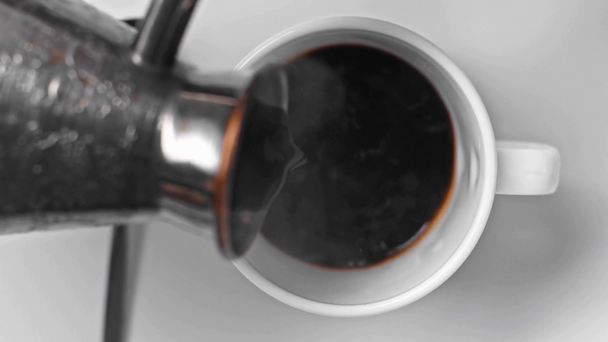 επιλεκτική εστίαση του τούρκικου μαύρου καφέ χύνοντας σε φλιτζάνι σε λευκό  - Πλάνα, βίντεο