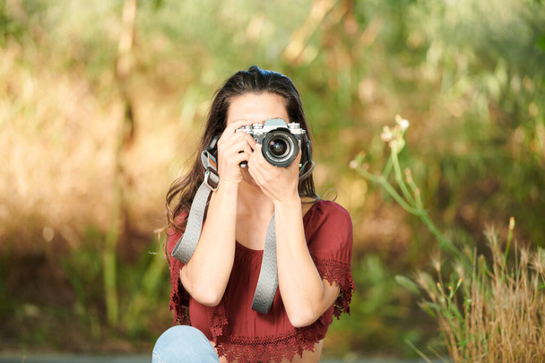 brunette taking pictures outdoors - Photo, Image