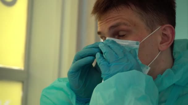 Tired doctor puts on a protective mask - Footage, Video