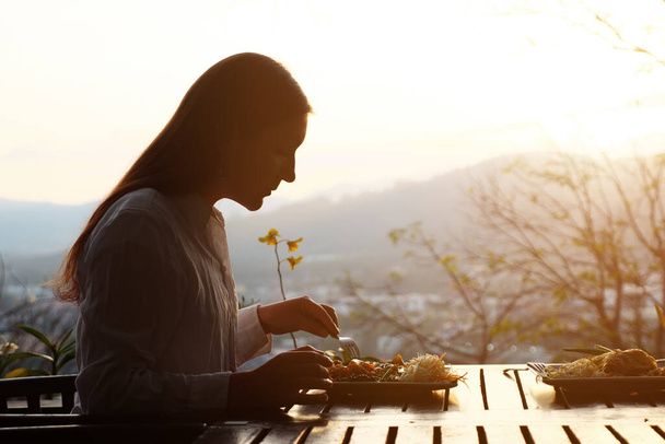 Brünette Frau isst in einem Café mit schöner Aussicht - Foto, Bild