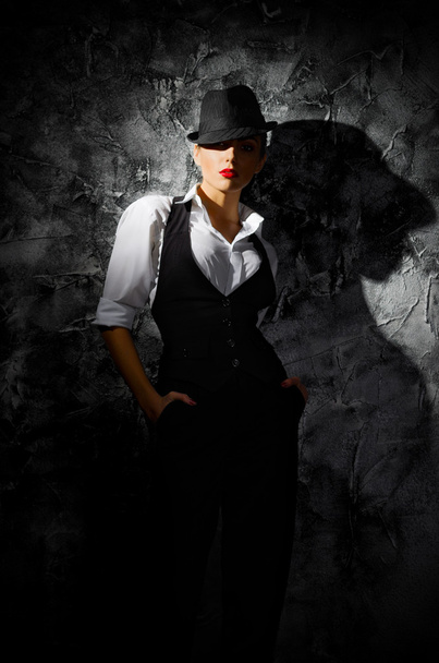 Portrait of young woman in hat on wall - 写真・画像