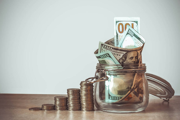 Coins Stack and US dollar bills in the glass jar. Concept of money saving, financial. Savings money and income Investment ideas and financial management for the future. Close up. Business Growth concept. Financial risk - Photo, Image