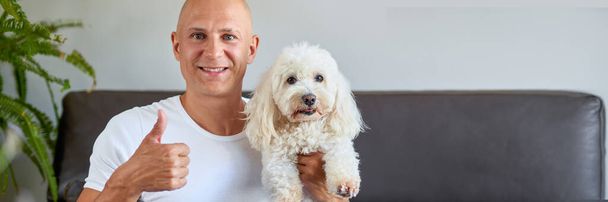 Красивый мужчина с симпатичной собакой дома
 - Фото, изображение