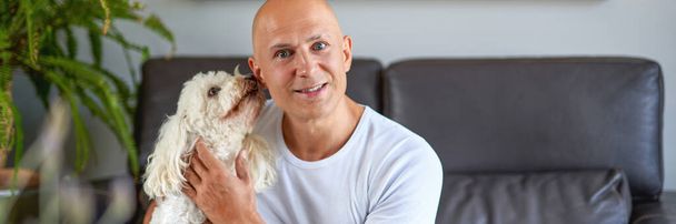 Handsome man with cute dog at home - Fotoğraf, Görsel