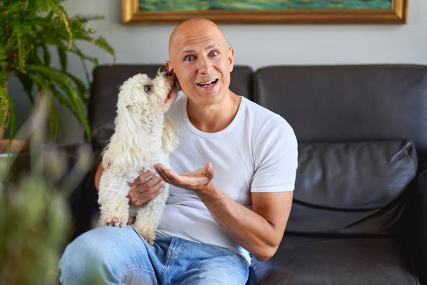 Handsome man with cute dog at home - Fotografie, Obrázek