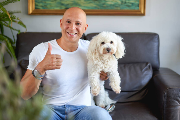 Handsome man with cute dog at home - Foto, Imagem