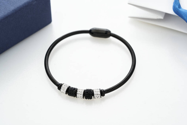 Primo piano colpo di bellissimo braccialetto nero con cristalli e vari charms, isolato su bianco.  - Foto, immagini