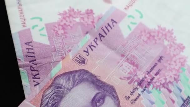 Különböző nagy címletű, 500, 200 és 1000 hrivnya értékű bankjegyek esnek az asztalra, és lassan forognak. Ukrán nemzeti valuta. Forgatás készpénz pénz közelkép háttér. Reklámok - Felvétel, videó