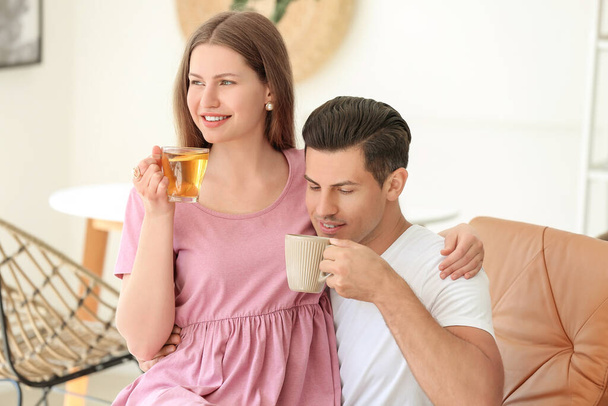 Szczęśliwa młoda para pije herbatę w domu - Zdjęcie, obraz