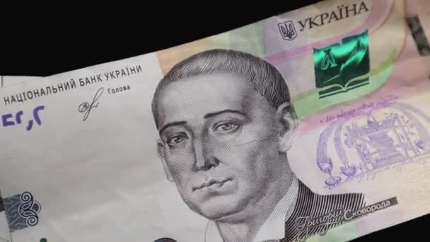 Les billets en valeur nominale de 500 hryvnias tombent sur une table noire et tournent lentement. Monnaie nationale ukrainienne. Revolving cash paper money close-up background. Commerciaux - Séquence, vidéo