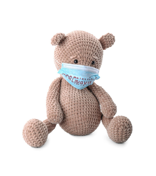 Медведь-игрушка с медицинской маской на белом фоне
 - Фото, изображение