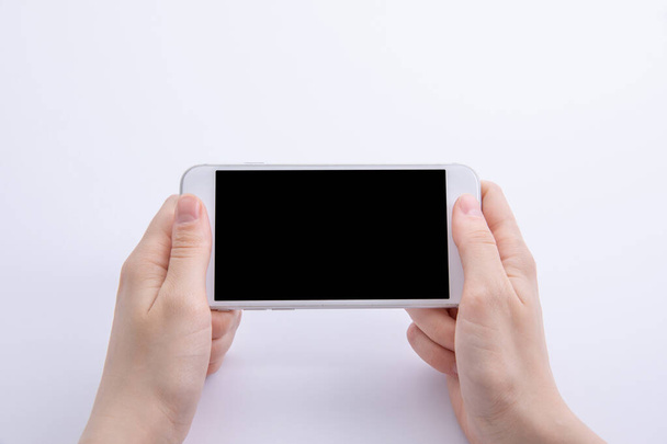 vrouwelijke handen met nieuwe moderne zwarte smartphone geïsoleerd op witte achtergrond, van dichtbij bekijken  - Foto, afbeelding