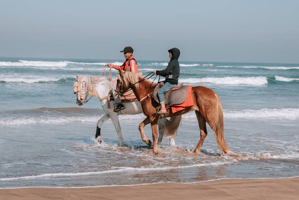 Fas kıyılarında, Fas 'ta, Fas' ta, tam gün batımında Deniz Önünde At Sürüşü - Fotoğraf, Görsel