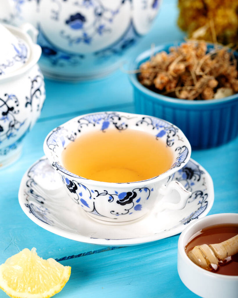 Cup of Linden Tea, Dried Linden Flowers in Cup with honey and lemon on wooden background. - Photo, Image