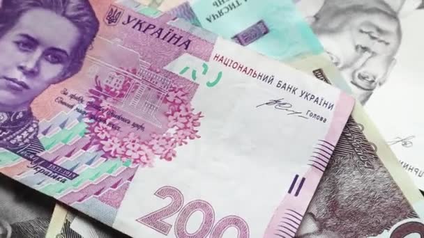 Muchos billetes en denominaciones de 1000, 500 y 200 hryvnia se extienden sobre la mesa y giran lentamente. Moneda nacional ucraniana. Fondo giratorio de dinero en efectivo en primer plano. Comerciales
 - Metraje, vídeo