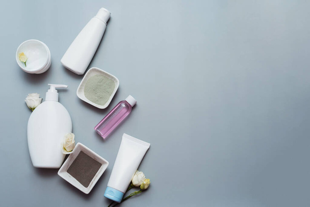 Cosmetics from natural ingredients and flower extracts on a gray background. - Foto, Imagen