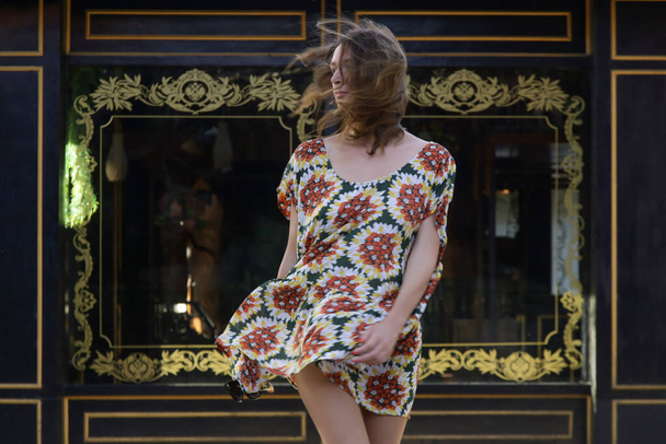 Portrait extérieur de femme élégante à la mode dans une large robe colorée devant une façade élégante. Tenue hippie boho estivale décontractée, tendance mode printemps-été. - Photo, image