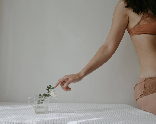 woman in lingerie touching the flower - Zdjęcie, obraz