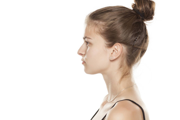 Profile of young serious woman on white background - Fotografie, Obrázek