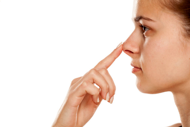 Profil młodej kobiety dotykającej nosa na białym tle - Zdjęcie, obraz