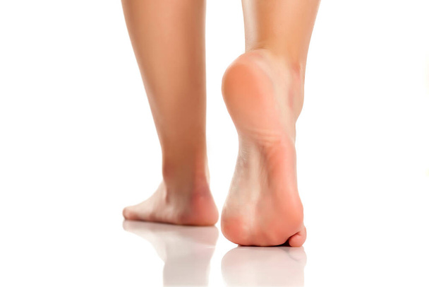 Weibliche nackte Füße auf weißem Hintergrund - Foto, Bild