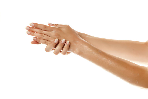 Крупный план женских рук с нанесением крема для рук на белом фоне
 - Фото, изображение