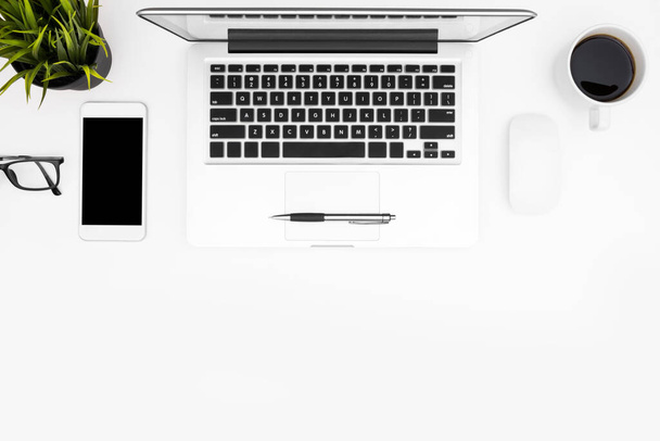 Tiszta fehér íróasztal laptoppal, kávé és kellékek. Felülnézet fénymásoló felülettel, nyúzás. - Fotó, kép