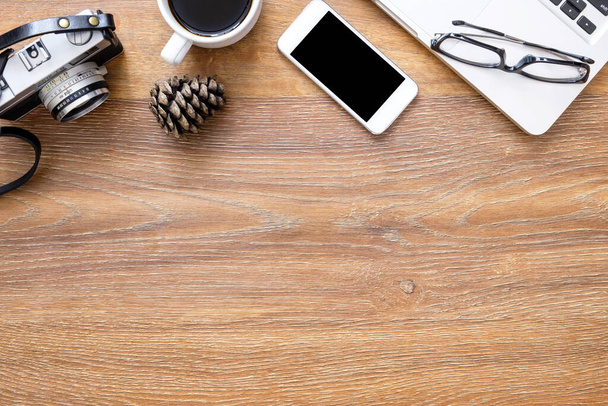 Дерев'яний стіл фотографа з плівковою камерою, смартфоном, ноутбуком, чашкою кави та приладдям. Вид зверху з простором для копіювання, плоский простір
. - Фото, зображення