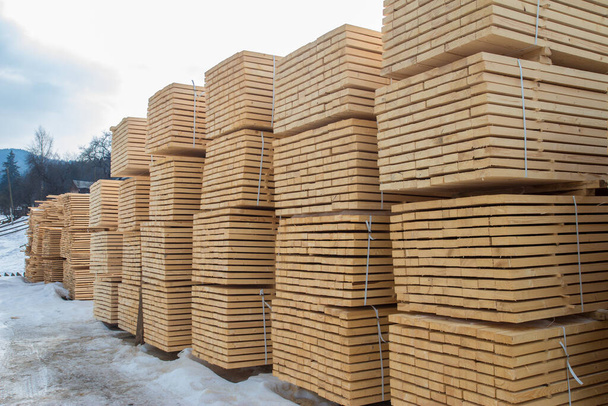 Entrepôt de bois en plein air. Poutres en bois, planches de bois, empilées en piles. Matériaux de construction. - Photo, image